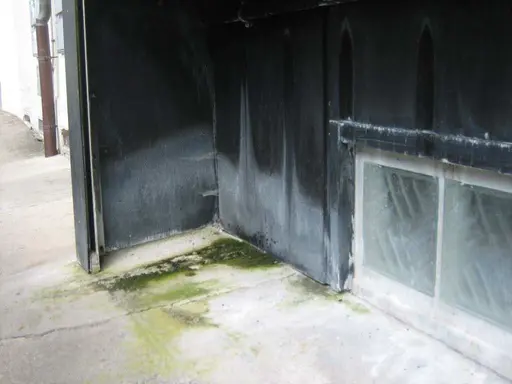 Eloxalfassade vor der Reinigung mit Ablagerungen und Moos